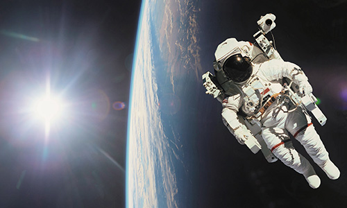 Astronaut in outer space with planet earth as backdrop. Elements